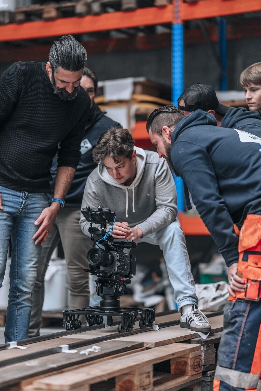 fotograaf en assistent bekijken een foto op het fototoestel in een magazijn van een klant