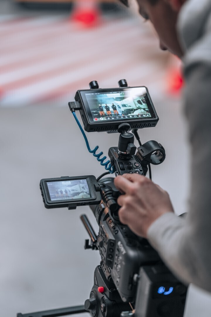 Een videograaf die met een professionele camera aan het filmen is
