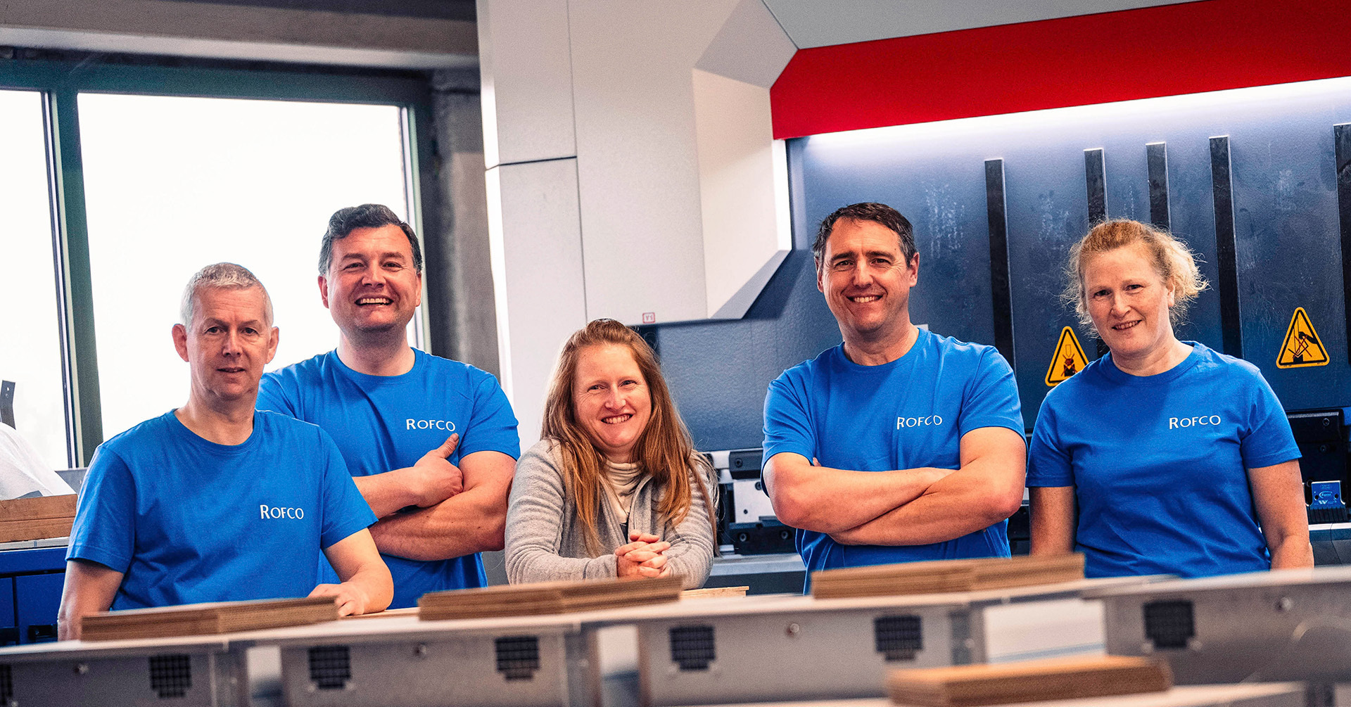 Groepsfoto van enkele werknemers van rofco met blauwe bedrijfskledij aan