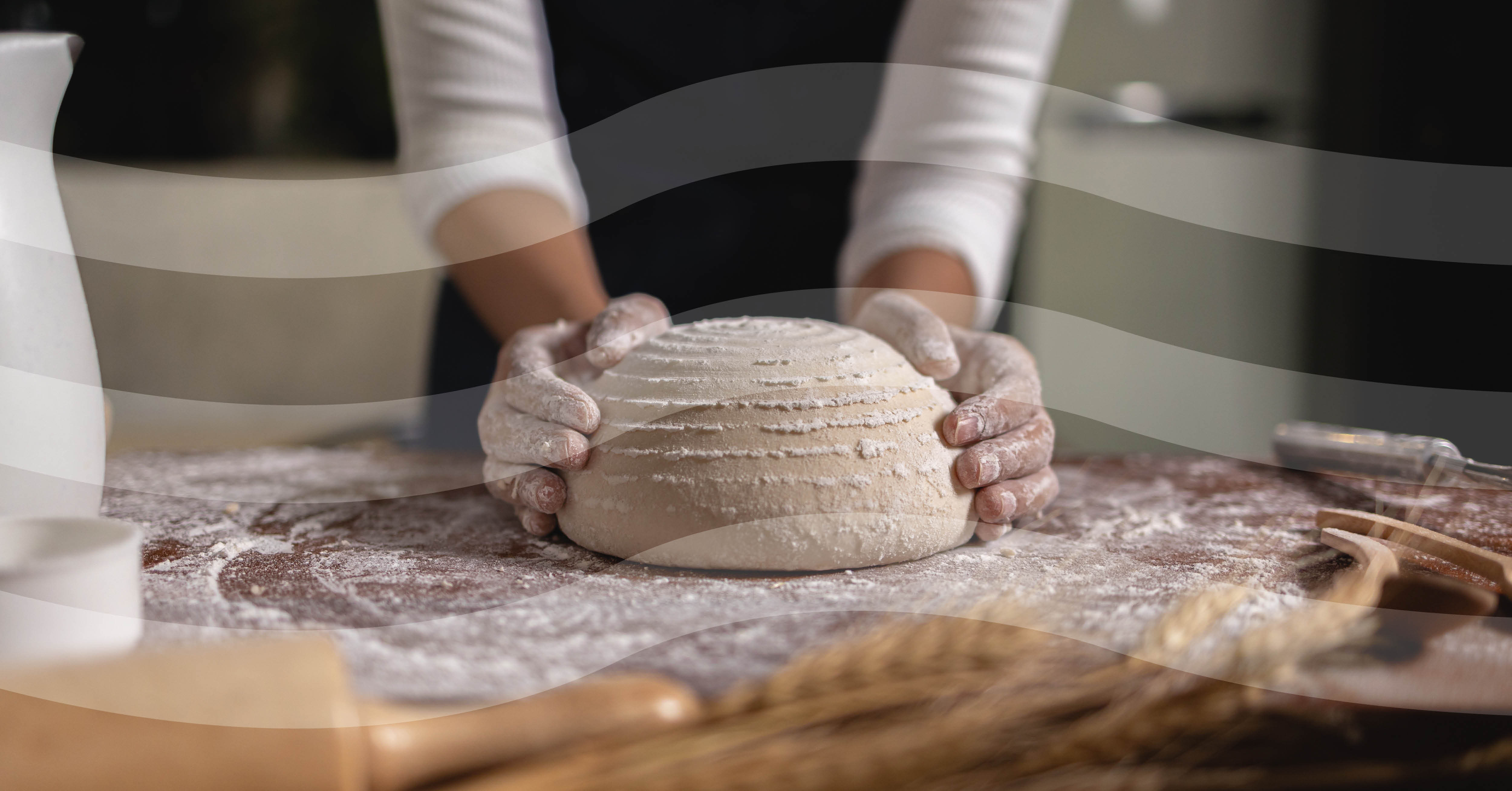 foto van een dame die een brood artisanaal aan het bakken is, ze kneed het deeg tot een ronde vorm